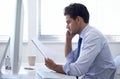 Businessman, paper and computer in office for report, information and brainstorming with notes at desk. Professional man Royalty Free Stock Photo