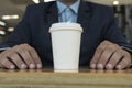Businessman and paper glass of coffee. Front view. Concept of coffee break.
