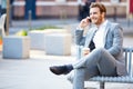 Businessman On Park Bench With Coffee Using Mobile Phone Royalty Free Stock Photo
