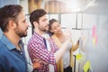 Businessman with partners looking at whiteboard in creative office Royalty Free Stock Photo