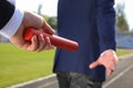 Businessman passing baton to his partner outdoors, closeup Royalty Free Stock Photo