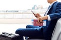 Businessman With Passport And Boarding Pass Sitting In Airport Departure Lounge Using Mobile Phone Royalty Free Stock Photo