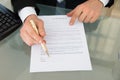 Businessman with pen and contract document at desk Royalty Free Stock Photo