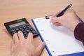 Businessman with pen poised above notepaper