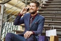 Businessman, phone call and bags on steps for shopping break, relax and networking in city. Male person, mobile and Royalty Free Stock Photo