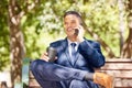 Businessman, phone call and coffee talking on bench outdoor in morning for online conversation, virtual meeting or relax Royalty Free Stock Photo