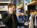 Businessman, phone call and shopping in boutique for retail, fashion and clothes in shop for sale. Male person Royalty Free Stock Photo