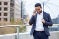 Businessman, phone call and umbrella with communication in city for justice, advocate for legal with tech. Male lawyer Royalty Free Stock Photo