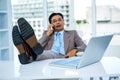 Businessman on the phone with his feet on his desk