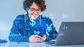 Businessman with phone and laptop, yuan with dollar glowing conversion icons Royalty Free Stock Photo