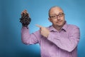 A businessman in a piked shirt holds grapes in hand Royalty Free Stock Photo