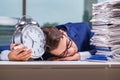 Businessman with pile stack of paper paperwork and an alarm cloc Royalty Free Stock Photo