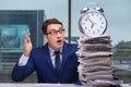 Businessman with pile stack of paper paperwork and an alarm cloc Royalty Free Stock Photo