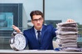 Businessman with pile stack of paper paperwork and an alarm cloc Royalty Free Stock Photo