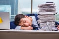 The businessman with pile stack of paper paperwork in the office