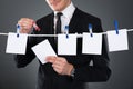 Businessman pinning blank papers on clothesline Royalty Free Stock Photo