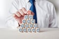 Businessman placing cube with happy smiling face symbol on top of tiered wooden cubes Royalty Free Stock Photo