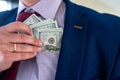 businessman placing dollar money into his pocket as after a successful deal or bribe Royalty Free Stock Photo