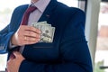 businessman placing dollar money into his pocket as after a successful deal or bribe Royalty Free Stock Photo