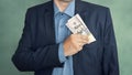 corrupt politician. businessman placing dollar money into his pocket as after a successful deal or bribe. corrupt Royalty Free Stock Photo