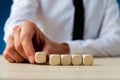 Businessman placing five blank wooden dices in a row Royalty Free Stock Photo