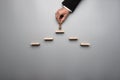 Businessman placing a king chess piece on a pyramid of wooden bl