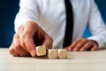 Businessman placing three blank wooden dices in a row Royalty Free Stock Photo
