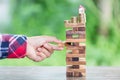 Businessman placing wooden block on a tower, Planning, risk an