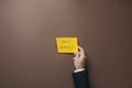 Businessman placing yellow paper with Dont worry sign over brown background Royalty Free Stock Photo