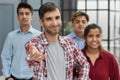 A businessman in a plaid shirt holds out his hand for a handshake. Royalty Free Stock Photo