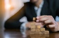 Businessman planing and strategy putting wooden blocks risk or success project Royalty Free Stock Photo