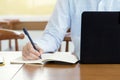 Businessman planning writing note and working with laptop computer on desk. Writing something idea on notebook or check list, Royalty Free Stock Photo