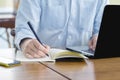 Businessman planning writing note and working with laptop computer on desk. Writing something idea on notebook or check list, Royalty Free Stock Photo