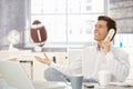 Businessman playing with football in office