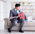 Businessman playing guitar at home Royalty Free Stock Photo