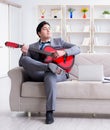 Businessman playing guitar at home Royalty Free Stock Photo