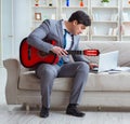 Businessman playing guitar at home Royalty Free Stock Photo