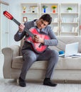 Businessman playing guitar at home Royalty Free Stock Photo