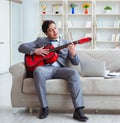 Businessman playing guitar at home Royalty Free Stock Photo