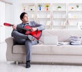 Businessman playing guitar at home Royalty Free Stock Photo