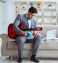 Businessman playing guitar at home Royalty Free Stock Photo