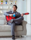 Businessman playing guitar at home Royalty Free Stock Photo