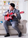 Businessman playing guitar at home Royalty Free Stock Photo