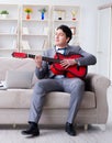 Businessman playing guitar at home Royalty Free Stock Photo