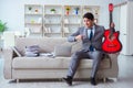 The businessman playing guitar at home Royalty Free Stock Photo