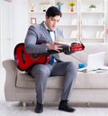 Businessman playing guitar at home Royalty Free Stock Photo