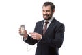 Cheerful bearded businessman listening music with earphones and pointing at smartphone with pinterest website