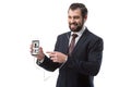 cheerful bearded businessman listening music with earphones and pointing at smartphone with pinterest website