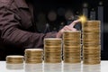 Businessman pointing spot on the graph finance chart with stack of a coin showing increase graph.