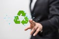 Businessman pointing to a 3D rendered green recycle sign